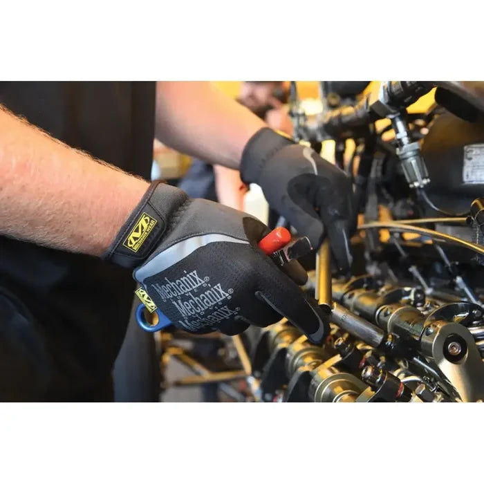Gloved hands working on a motorcycle engine or mechanical components.