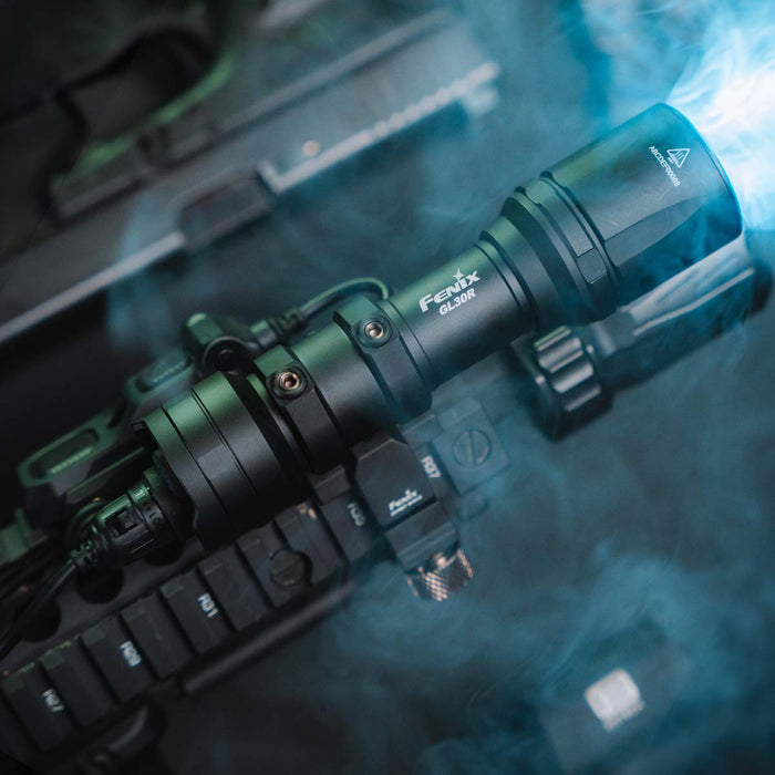 Fenix GL30R flashlight on a reflective surface with a blurred background