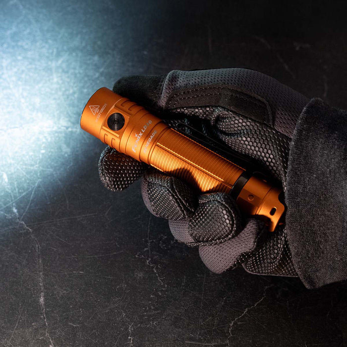 Fenix LD30 RENEGADE flashlight held in a black glove against a dark background
