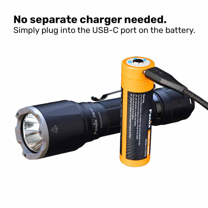 Fenix TK17 flashlight with battery being charged with a USB-C cable on a white background