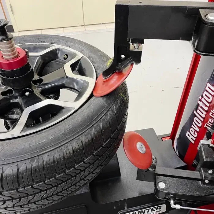 Car tire on alloy wheel with Hunter Revolution Tire Changer in action